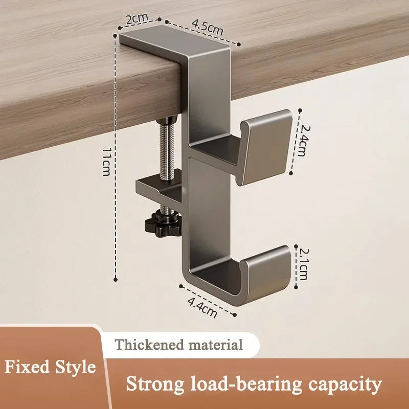 A silver metal desk hook with a fixed style design shown mounted on a wooden surface.