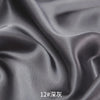 Close-up of smooth gray satin fabric draped and folded to show texture and sheen.