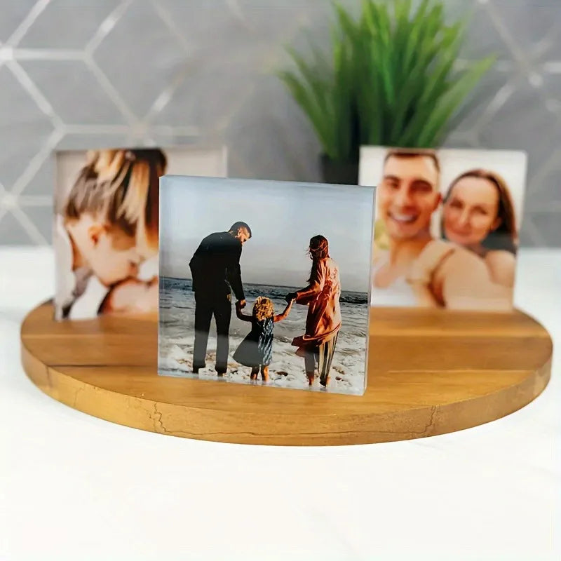 A wooden stand displaying a personalized acrylic photo ornament featuring family portraits.