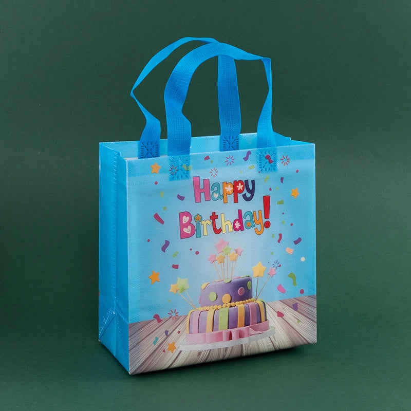 A light blue reusable happy birthday gift bag with a colorful floral cake design and a pink ribbon.