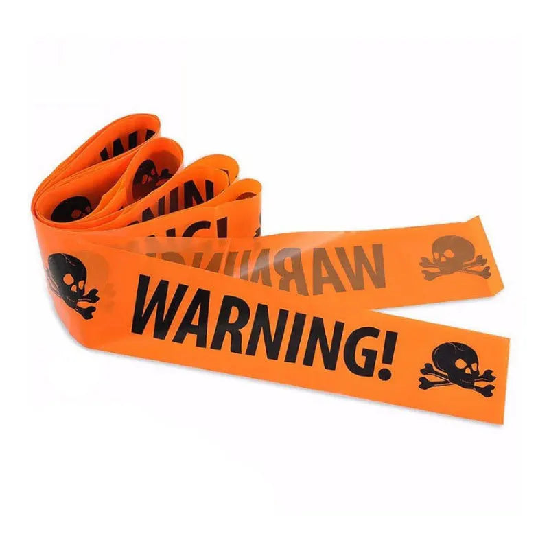 Orange caution tape with skull and crossbones warning text rolled up for Halloween decor