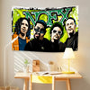A vibrant tapestry featuring the band NØEX in a graffiti style, displayed on a wall above a wooden desk.