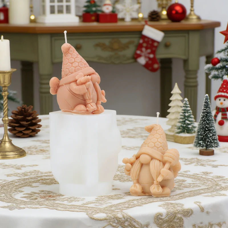A light pink silicone candle mold shaped like a gnome with a honeycomb hat sitting on a white pedestal.