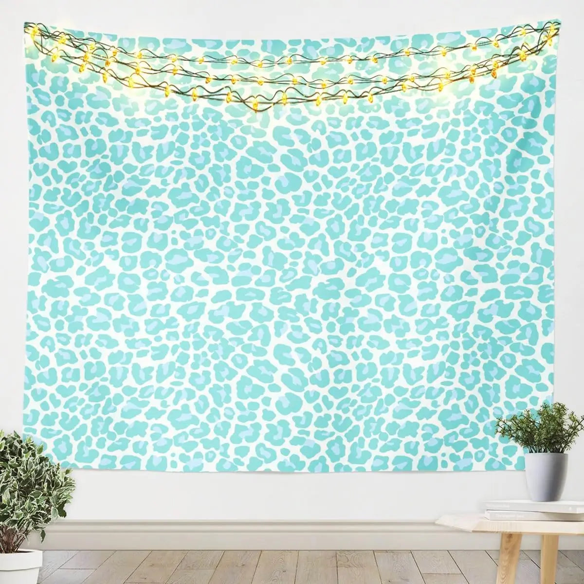 A light blue leopard print tapestry wall hanging decorated with string lights.