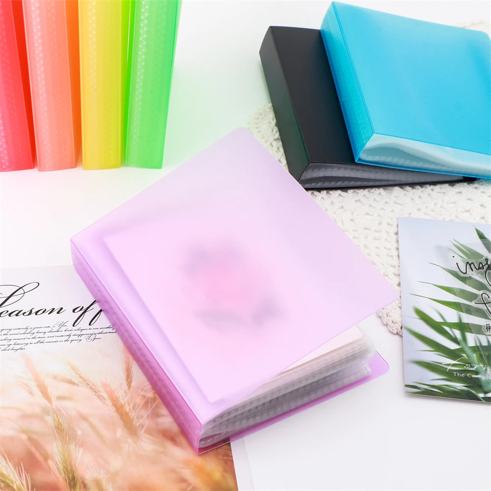 A pink clear A6 storage album with 40 pages is shown next to colorful pens and a green notebook.