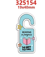 A light blue resin craft embellishment shaped like a key with the text Reading is progress and Do not disturb