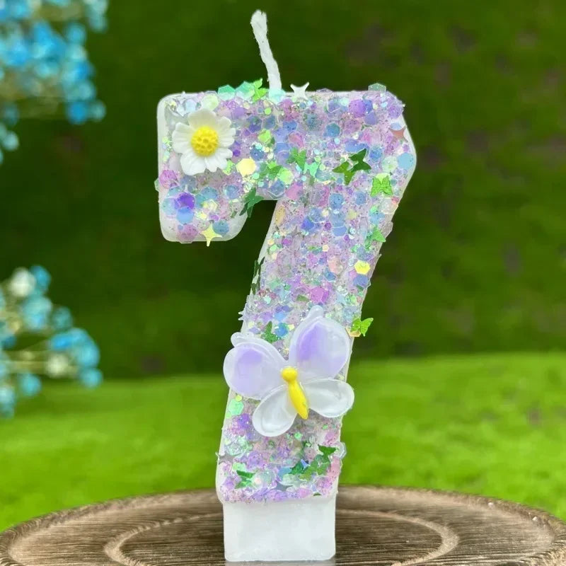 A white number seven cake candle decorated with purple and green floral accents and a pale purple butterfly