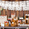 Holztischdisplay mit handgeschnittenem Papelpicado-Banner und Partydekorationen.