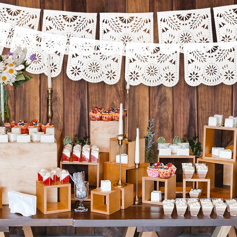 Holztischdisplay mit handgeschnittenem Papelpicado-Banner und Partydekorationen.