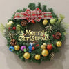 A festive Christmas wreath decorated with pine greenery, red plaid ribbon, and gold and green ornaments.