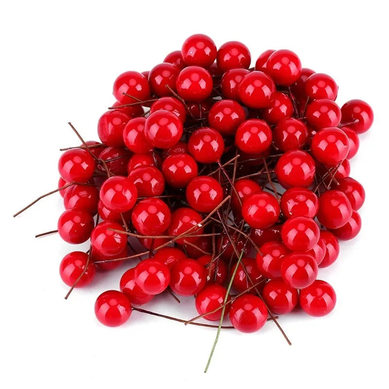 Un grupo de bayas de acebo artificiales de color rojo brillante para decoración navideña.