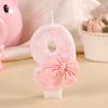 A pink glitter candle shaped like the number 8 with a pink bow, displayed on a light background.
