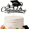 A white tiered cake decorated with a black graduation cap topper and floral accents.