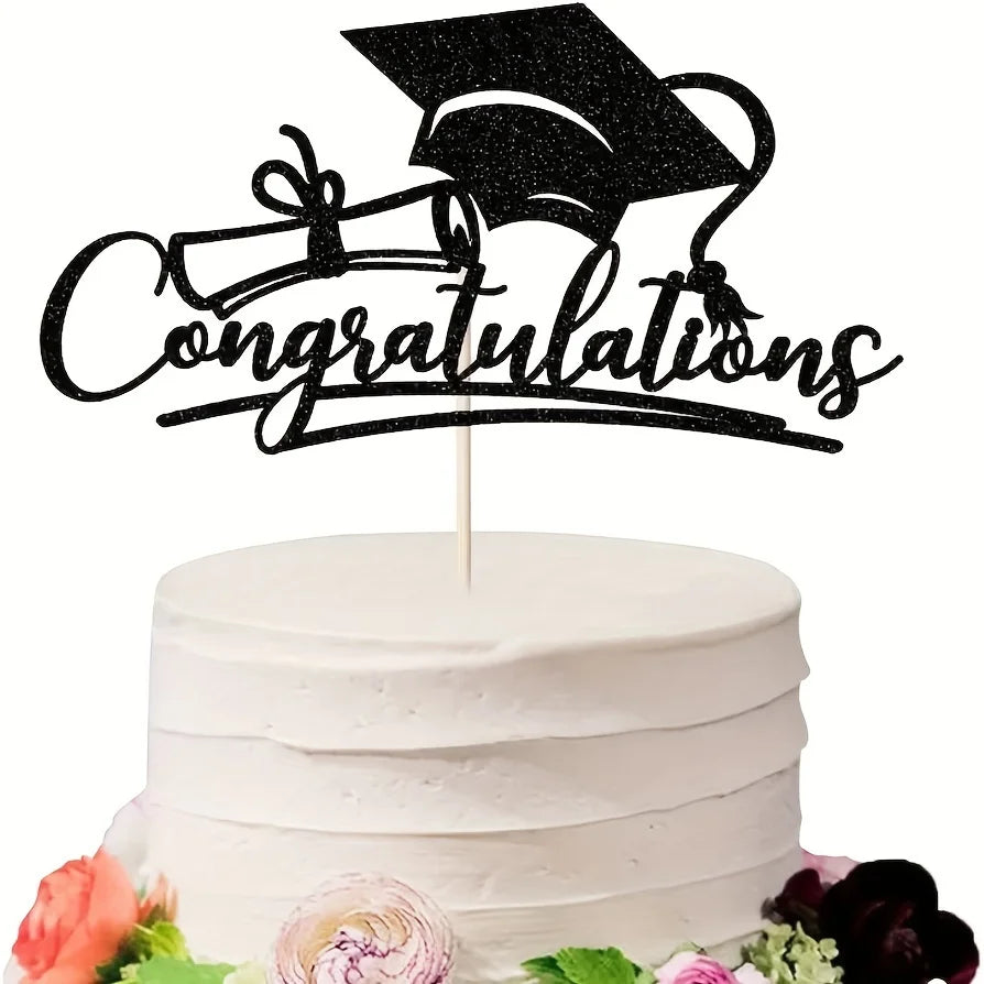 A white tiered cake decorated with a black graduation cap topper and floral accents.