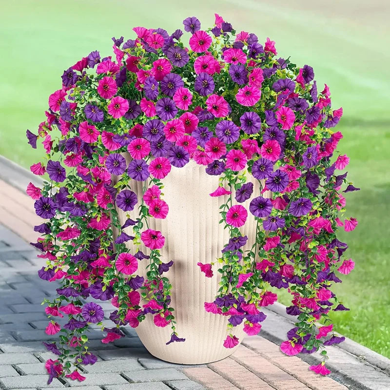 A vibrant arrangement of artificial morning glory flowers in shades of purple and pink cascading from a white vase.