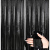 A hand reaches through black metallic foil fringe curtains, showing the texture and drape of the fabric.