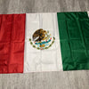 A banner displaying the flag of Mexico with its coat of arms, featuring red, white, and green panels.