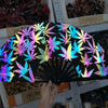 A black folding bamboo hand fan with neon light accents is displayed against a background of other decorative items.