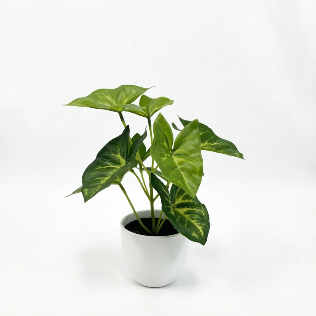 A vibrant green artificial potted plant with variegated leaves sits in a white ceramic pot.