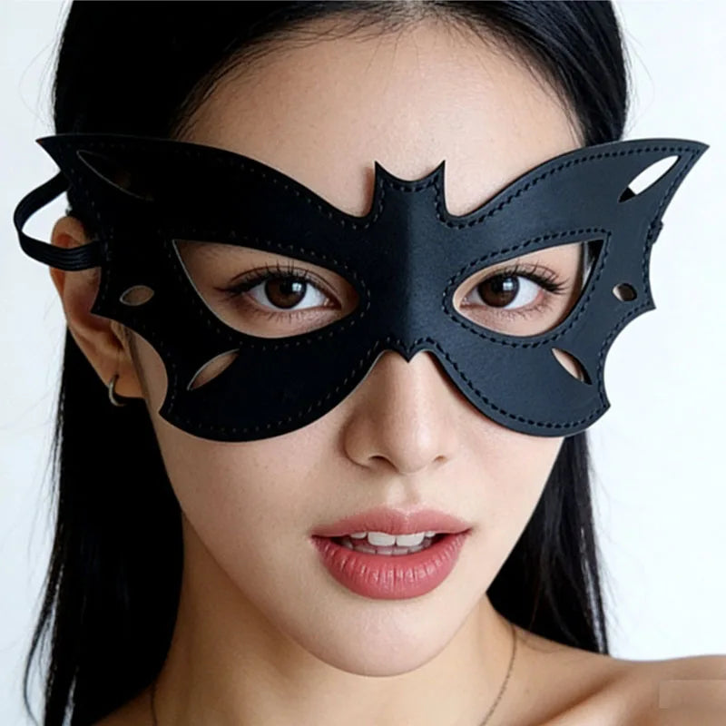 A close-up of a woman wearing a black PU leather cat eye masquerade mask.