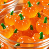 A bowl filled with bright orange mini artificial pumpkins for fall decoration.