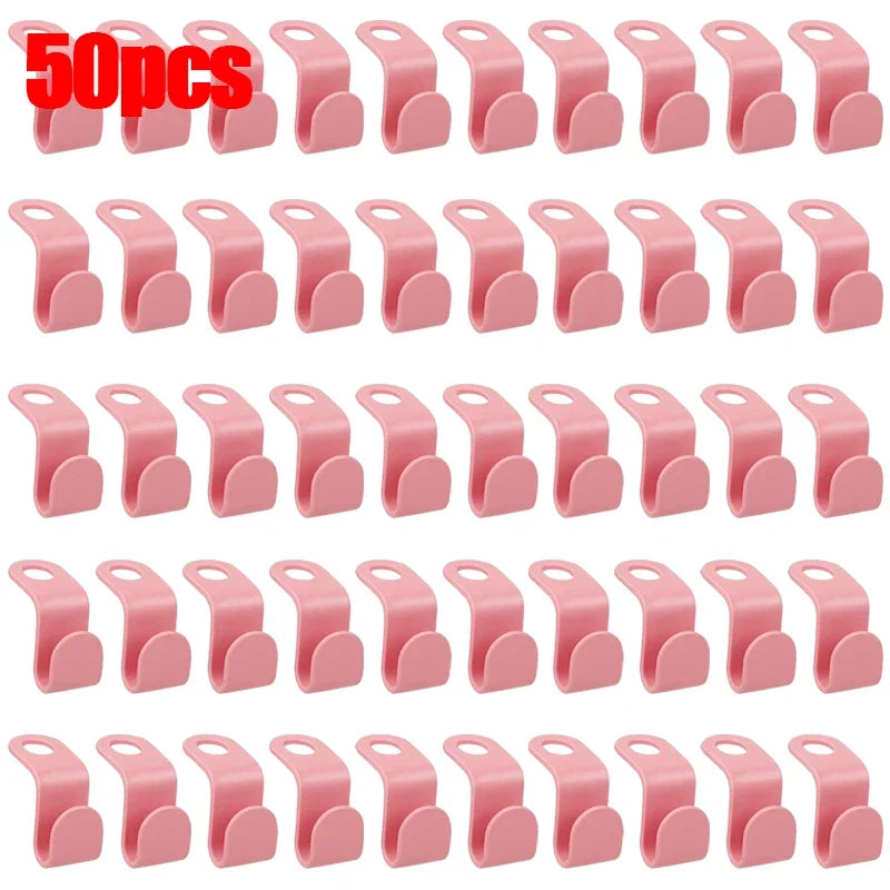 A set of 30 pink space-saving hanger connector hooks for organizing clothing.