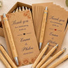 A collection of personalized engraved bamboo pens and thank you cards arranged in a wooden box.