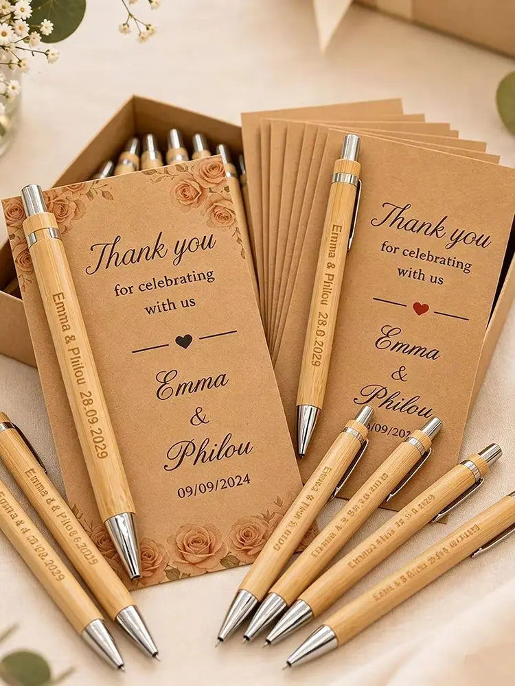 A collection of personalized engraved bamboo pens and thank you cards arranged in a wooden box.
