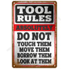 A vintage tin sign with black and red text that reads TOOL RULES ABSOLUTELY DO NOT TOUCH THEM MOVE THEM BORROW THEM LOOK AT T