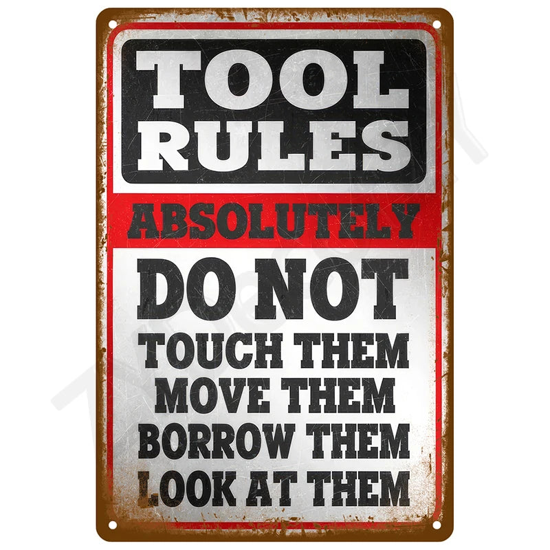 A vintage tin sign with black and red text that reads TOOL RULES ABSOLUTELY DO NOT TOUCH THEM MOVE THEM BORROW THEM LOOK AT T