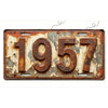 A vintage, rusted aluminum license plate tag displaying the year 1957.