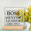 A clear acrylic plaque with text appreciating a boss, mentor, and leader, set on a wooden base.