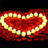 Forme de cœur faite de bougies blanches lumineuses entourées de pétales de roses rouges artificielles.