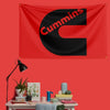 A red flag banner featuring a large black letter C with the word Cummins printed in red text.