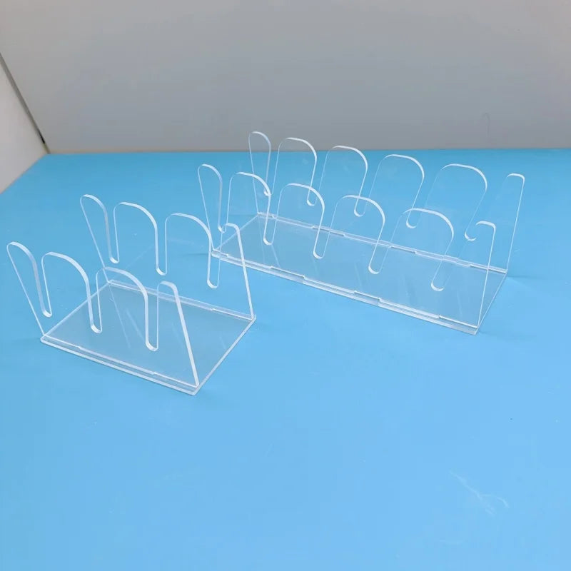 Clear acrylic hat storage rack with multiple hooks displayed on a blue surface.