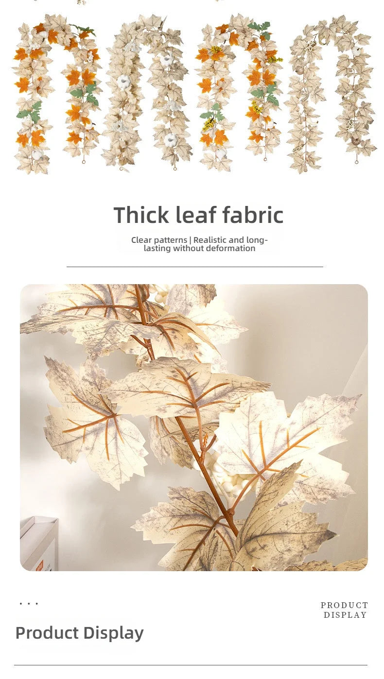 A display of thick leaf fabric garlands featuring realistic autumn maple leaves in shades of orange, green, and beige.