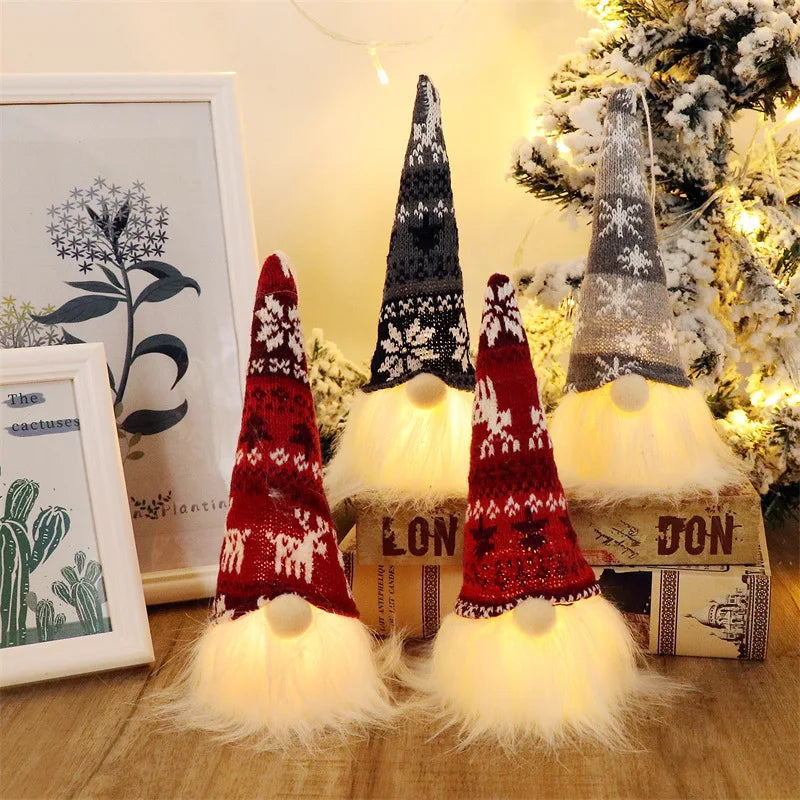 A display of illuminated LED gnome Christmas decorations with warm glow against a snowy background.