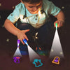 A child is using Halloween LED finger projector lights to cast spooky designs onto a surface.