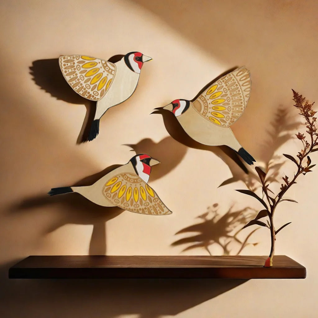 Three vintage wooden bird wall decorations with natural wood tones and painted details cast shadows on a beige wall.