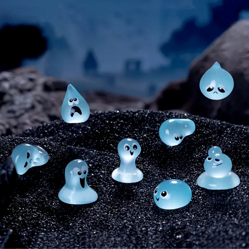 A set of eight glow-in-the-dark resin fairy water droplet figurines resting on a dark, textured surface.