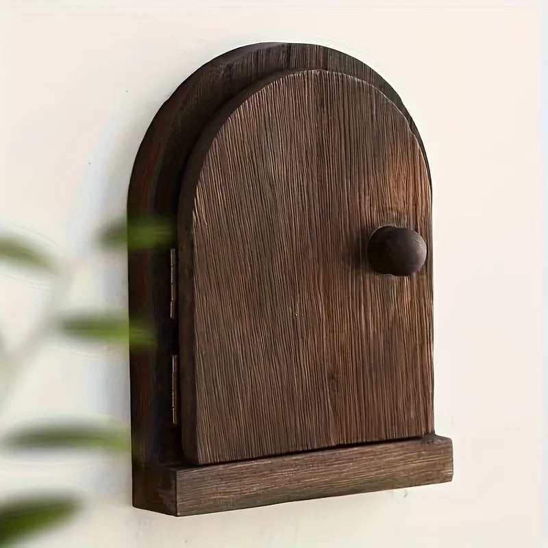 A dark brown wooden decorative outlet cover with an arched design mounted on a white surface.