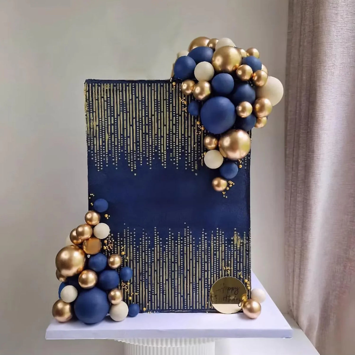 A set of blue, white, and gold ball cake toppers arranged in a vertical display.