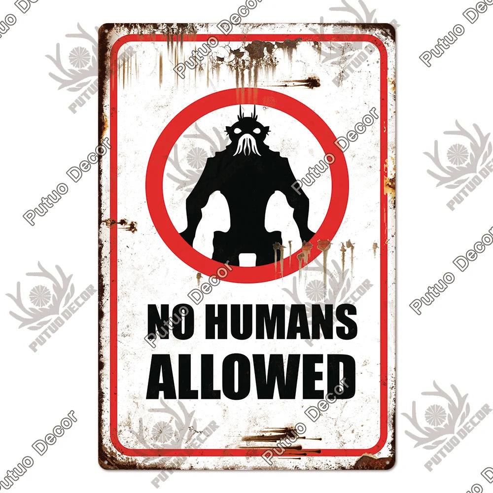 A vintage warning metal sign with a red border and black silhouette of a skull, reading NO HUMANS ALLOWED.