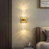 Modern bubble crystal LED wall sconces mounted on a beige wall above a dark wood nightstand.