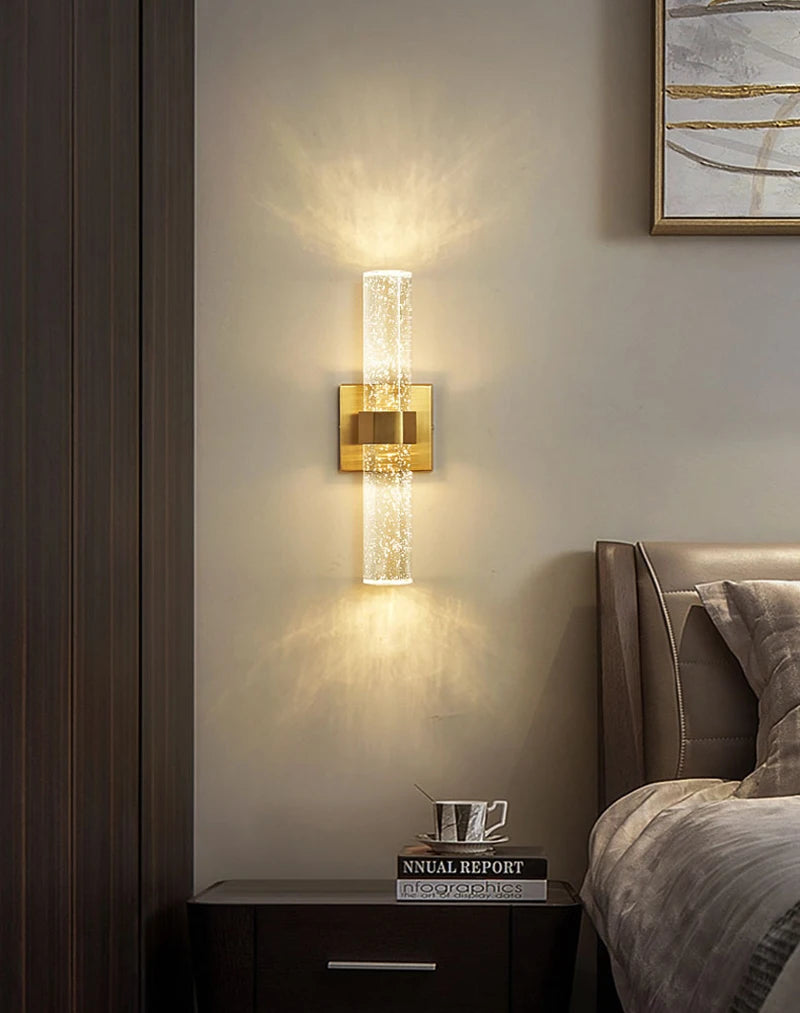 Modern bubble crystal LED wall sconces mounted on a beige wall above a dark wood nightstand.