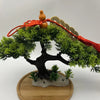 Traditional Chinese knot pendant featuring a wooden gourd and copper coins atop a green bonsai-style tree.