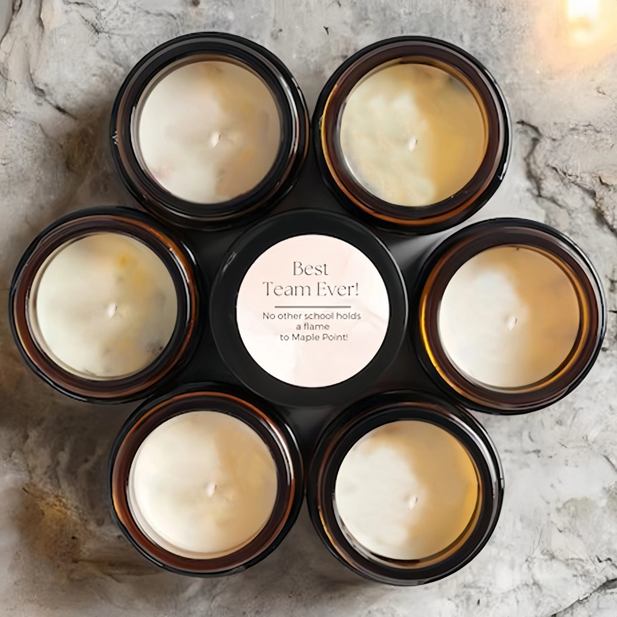 A collection of nine small jars filled with white scented soy wax candles arranged in a circular pattern on a light surface.