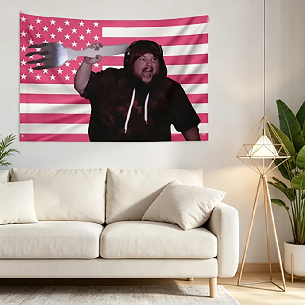 Eine Person in einem dunklen Hoodie hält aggressiv eine weiße Gabel vor einer rosa-weißen amerikanischen Flaggen-Tapisserie.