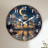Horloge murale avec croissant islamique et reflet d'un paysage nocturne sur l'eau.