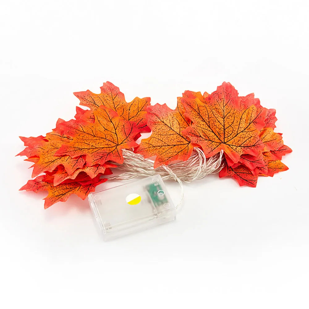 A cluster of bright orange and red faux maple leaves attached to a small clear plastic housing with LED lights.